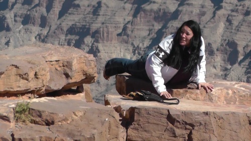 Girl hangs over edge of Grand Canyon